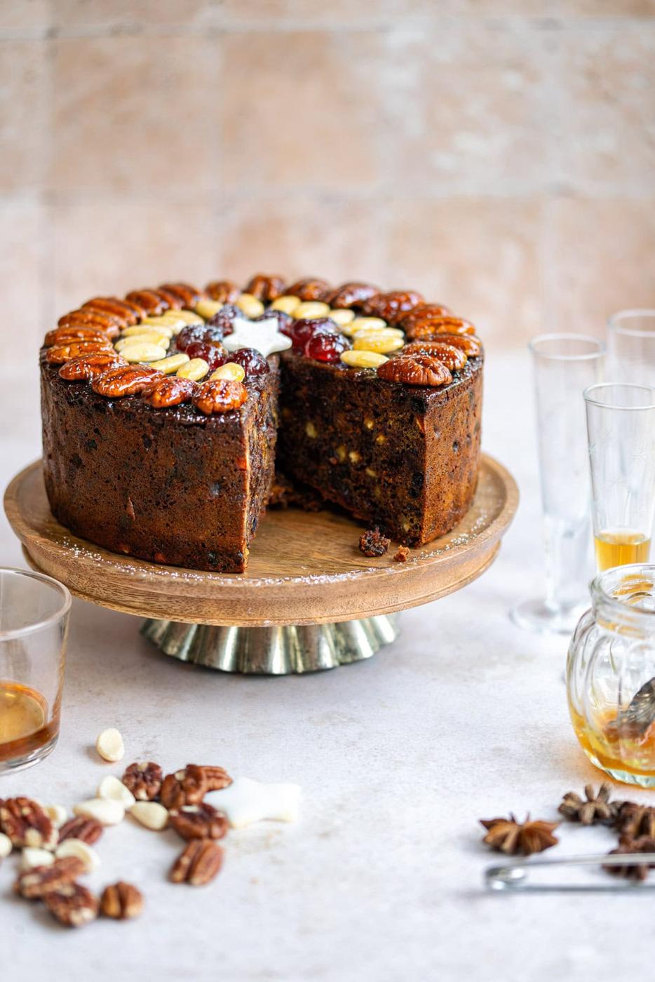Moist Christmas fruit cake with large slice cut out on a stand