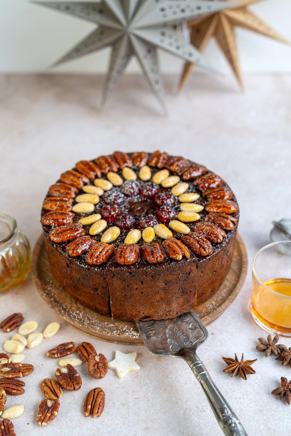 four ingredient Christmas fruit cake decorated with pecans, almonds and glacé cherries