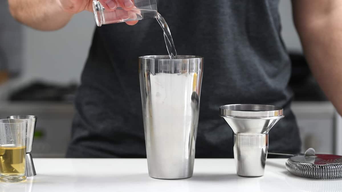 Adding gin to cocktail shaker