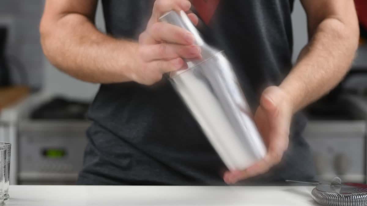 man shaking cocktail shaker