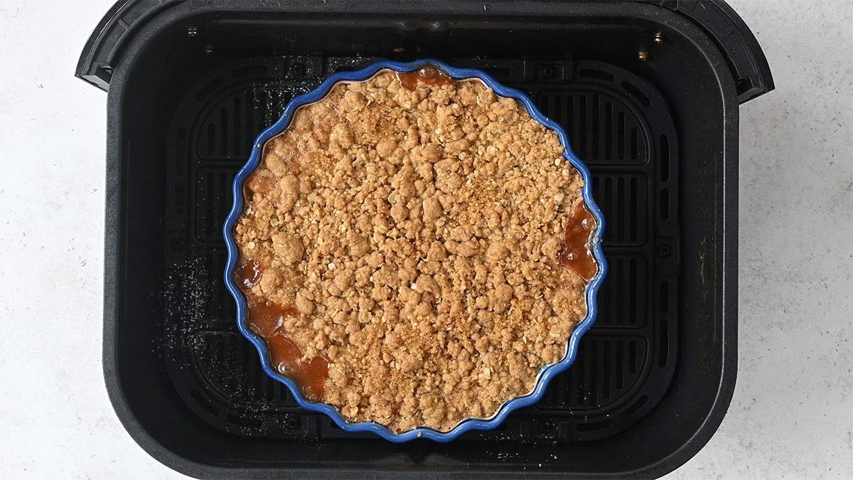 apple crumble baking in the basket of an air fryer