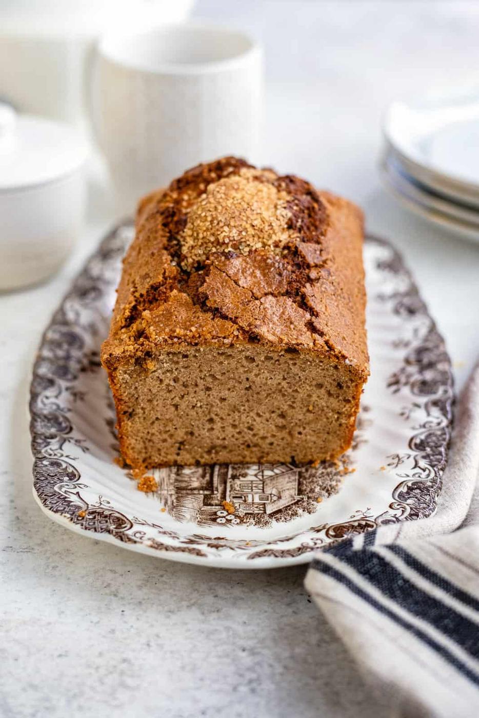 Air fryer banana bread on a platter with one slice cut