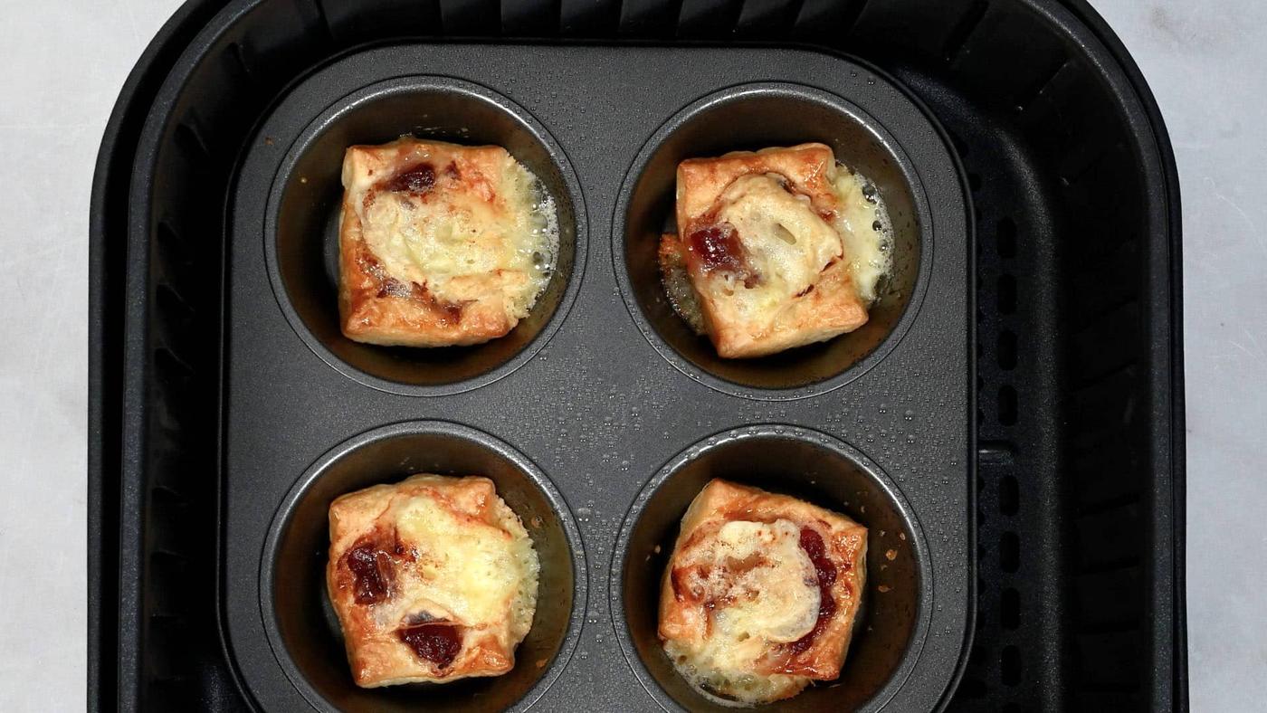 brie and cranberry puff pastry bites in the basket of an air fryer