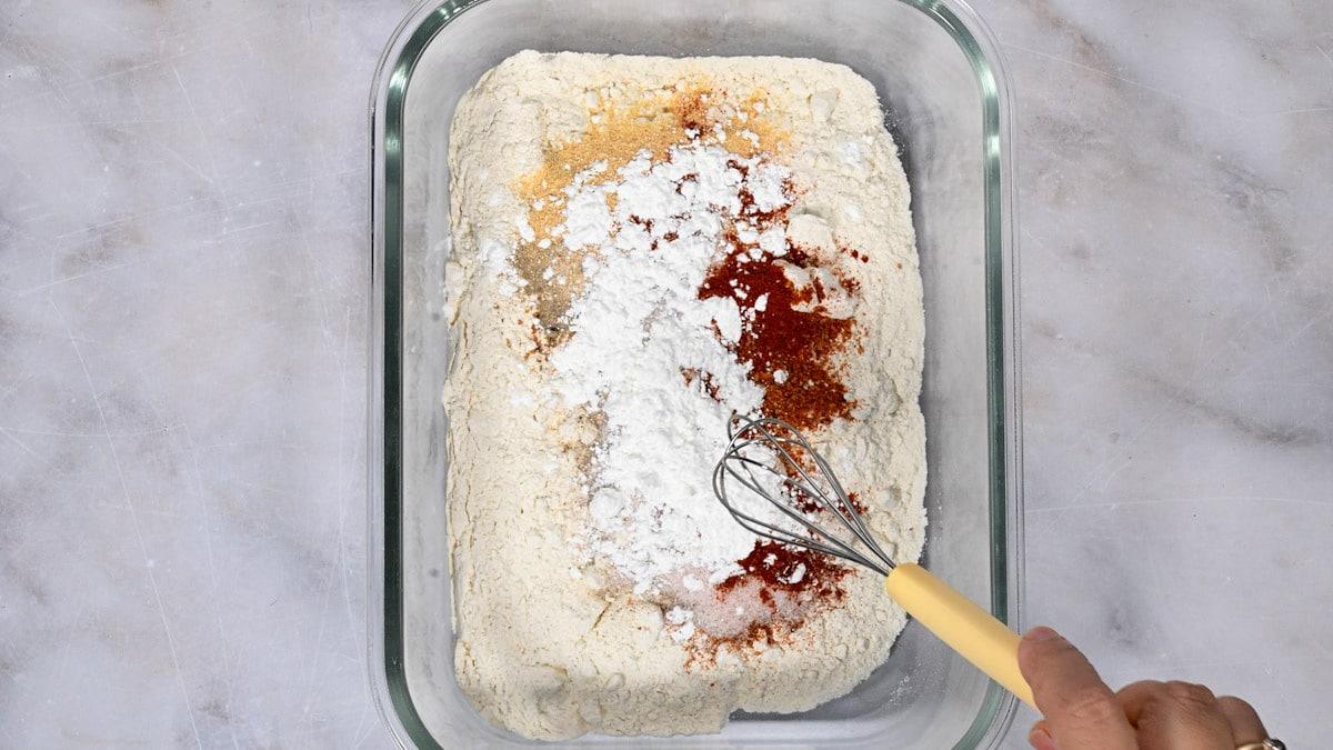 mixing ingredients for buttermilk fried chicken flour coating in a glass dish