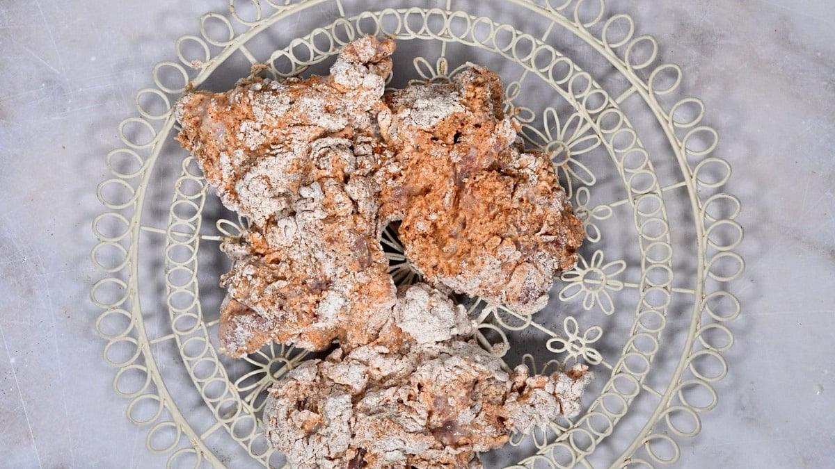chicken thighs coating with flour and sprayed with oil on a wire rack
