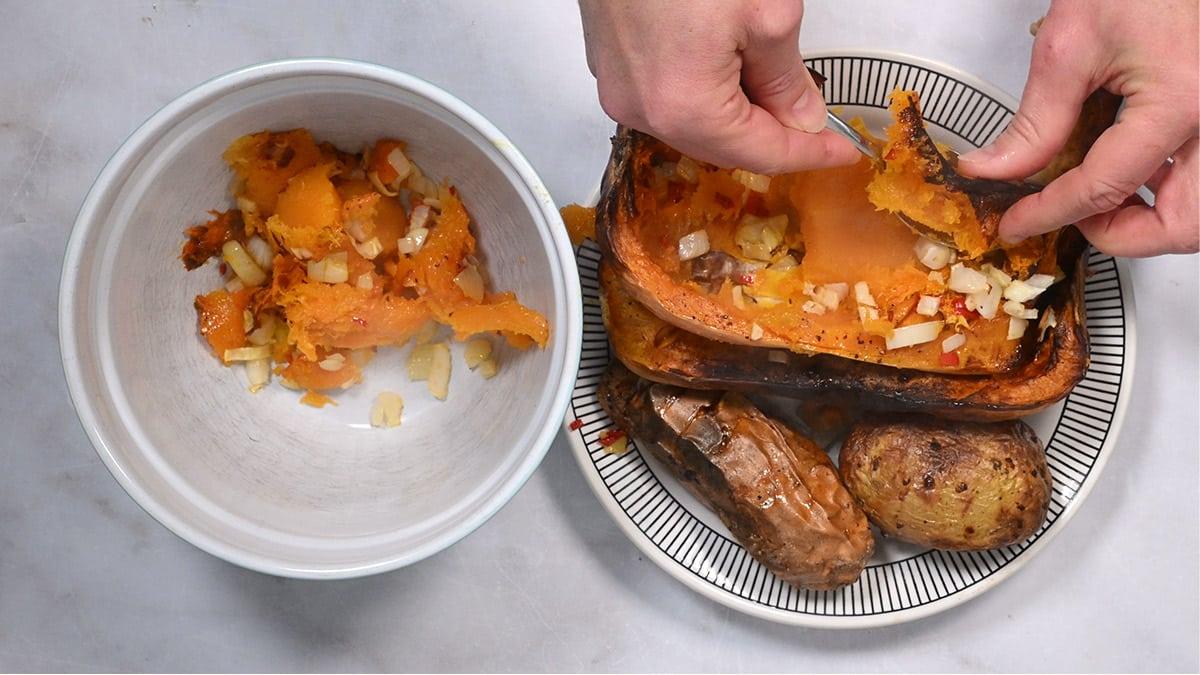 scooping the flesh out of roasted vegetables