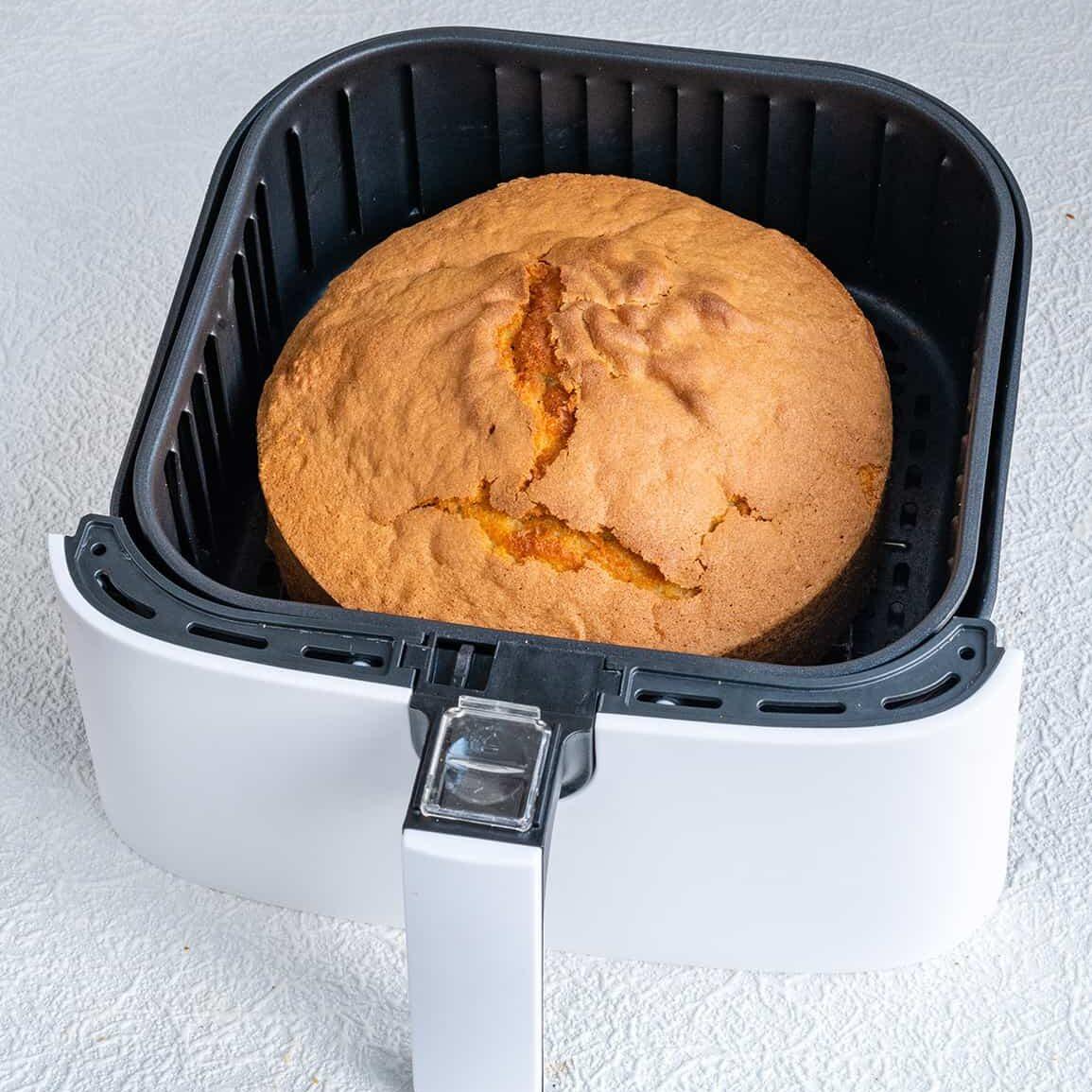 Air fryer with a sponge cake in the basket