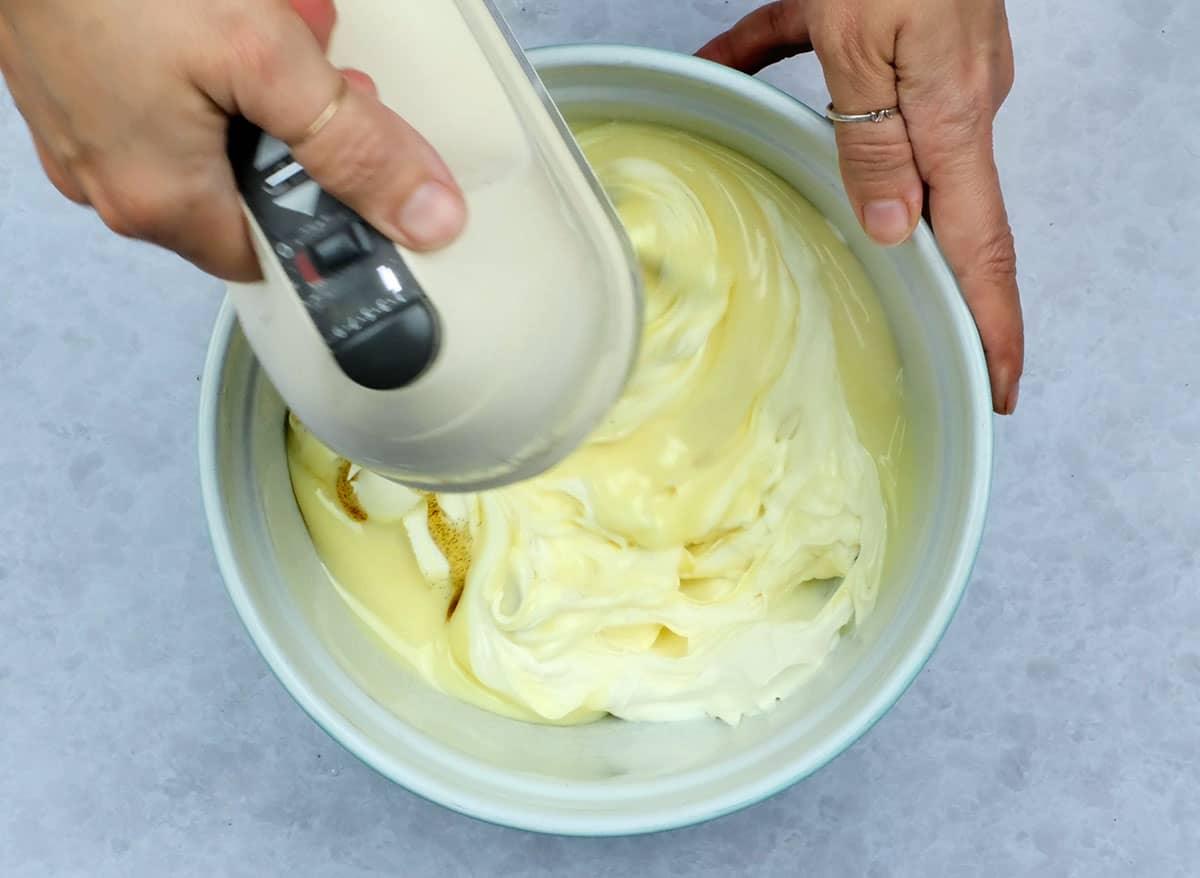Beating cheesecake filling with an electric hand mixer