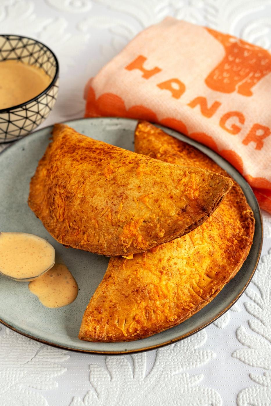 Two air fryer cheesy chicken crispanadas on a plate