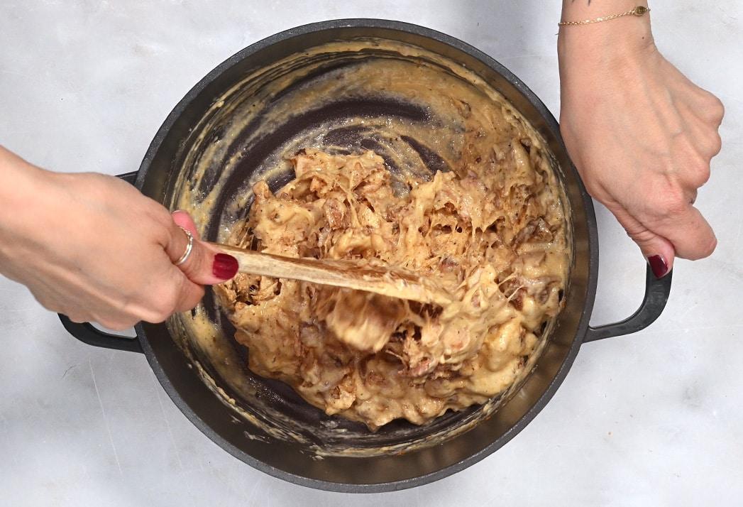 stirring shredded chicken into cheese sauce