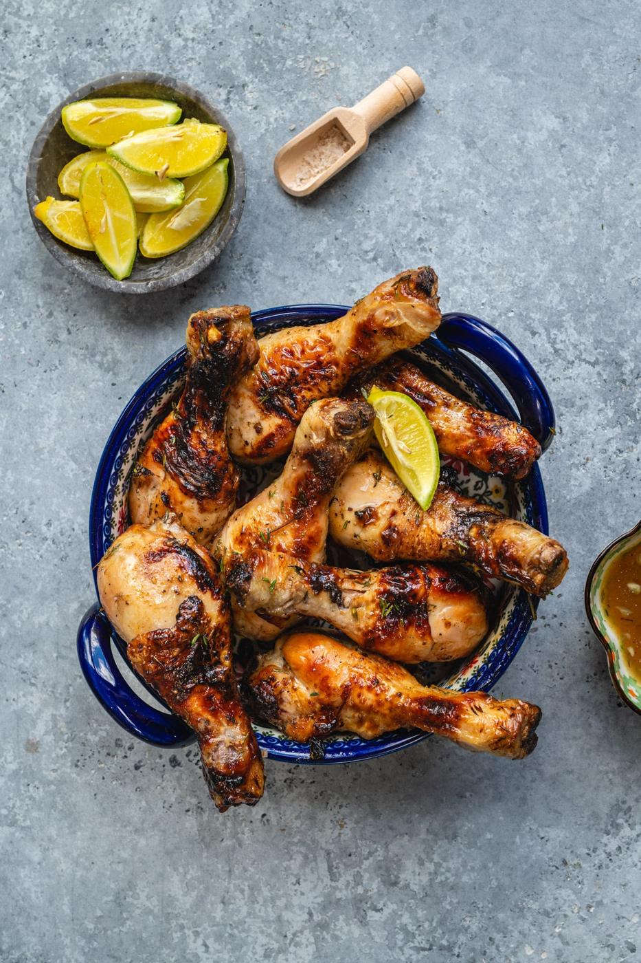 overhead shot of air fried chicken legs with lime wedges on the side