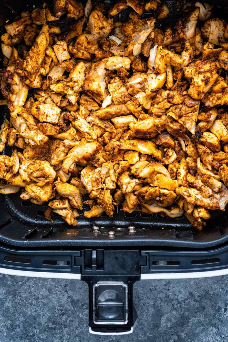 Sliced chicken sharwama in an air fryer basket