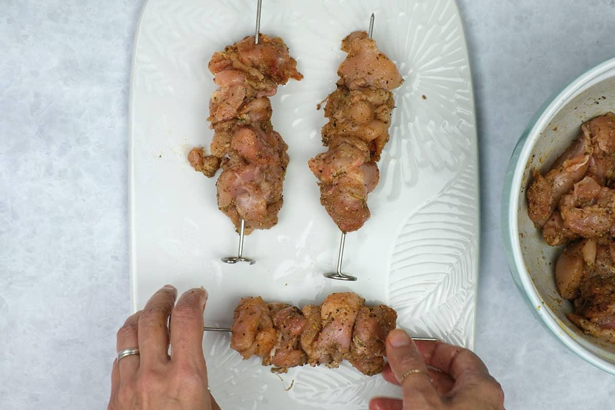 threading chicken onto skewers