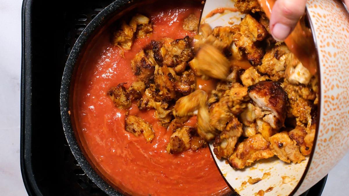 adding chicken chunks to masala sauce