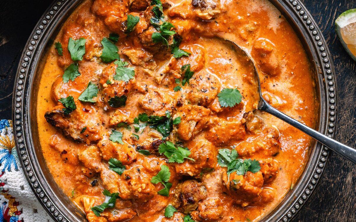 Bowl of chicken tikka masala garnished with fresh coriander