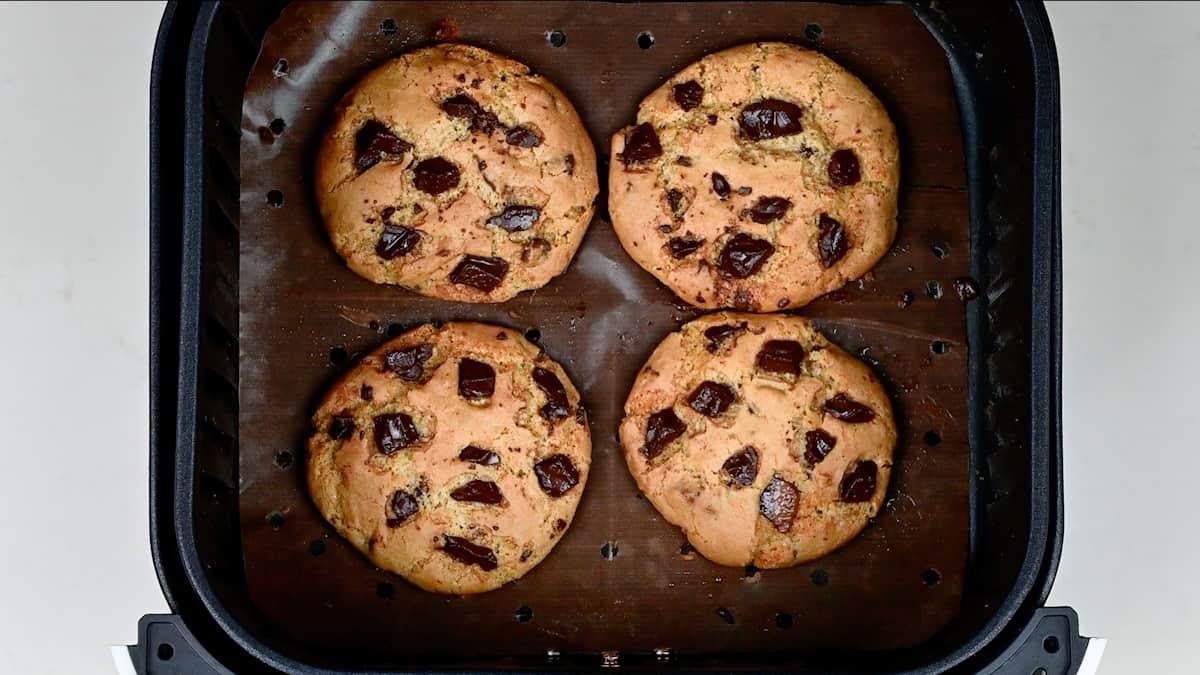 chocolate chip cookies in the basket of an air fryer after cooking