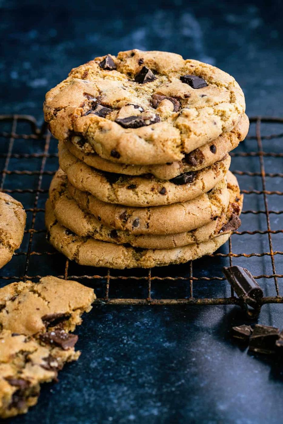 Chocolate chip cookies in a stack on a wire rack.