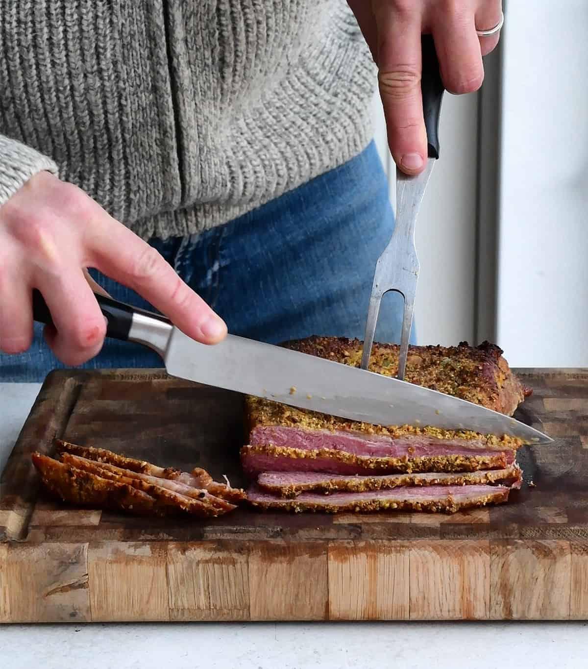 Man slicing corned beef on a butcher block