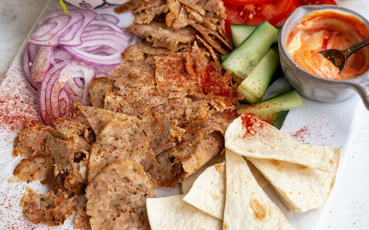 Air fryer doner served as a salad with lettuce, tomatoes, cucumber, onions, pita bread