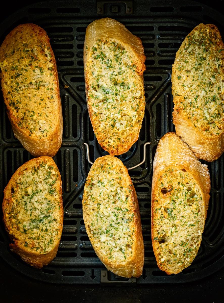 garlic bread slices in the basket of an air fryer