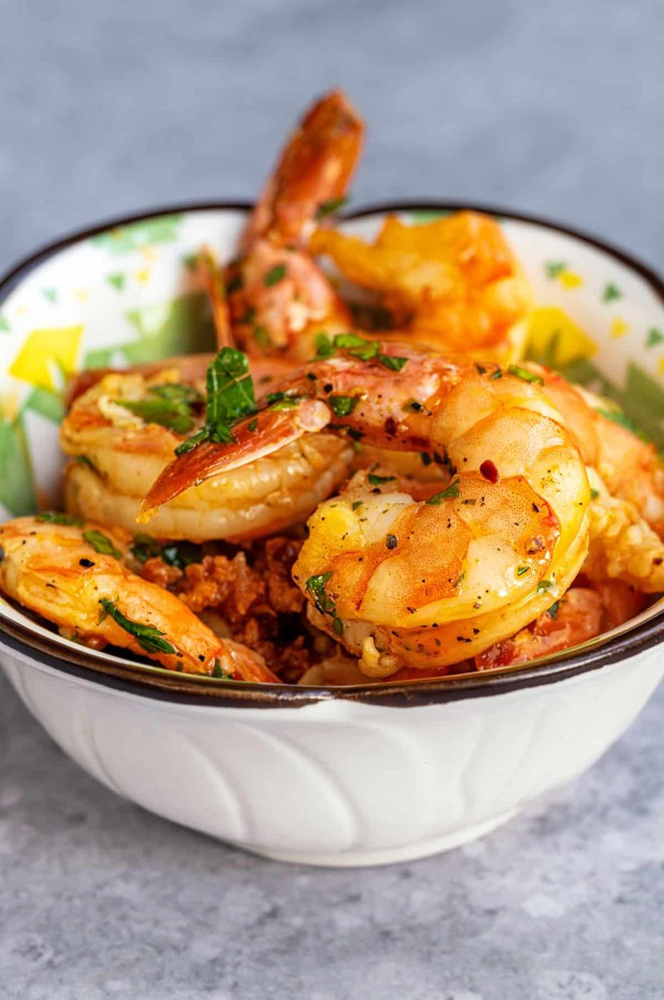small tapas bowl of air fryer garlic prawns garnished with chopped parsley