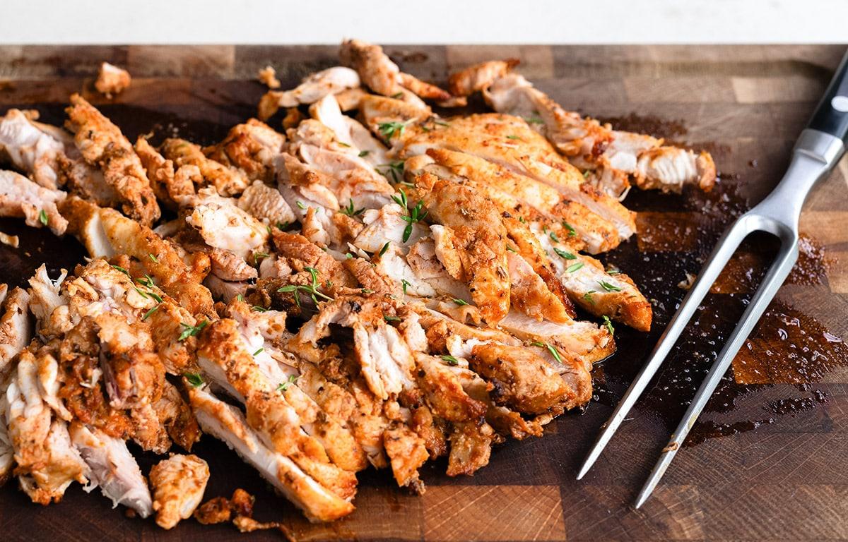 Air fryer Greek chicken, sliced, on a butchers block