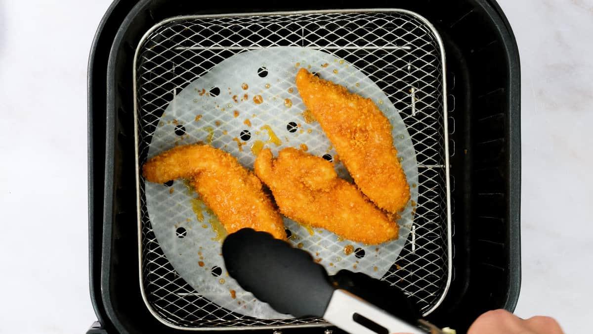 Chicken strips in an air fryer basket