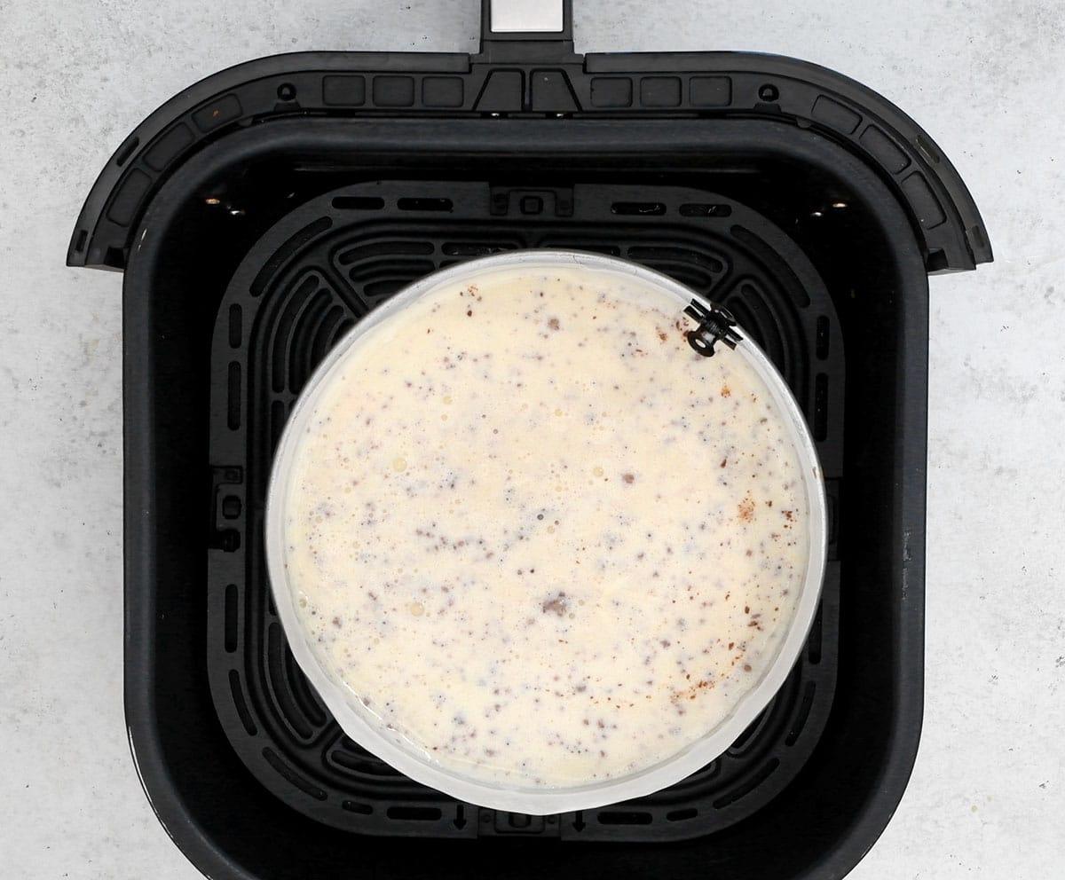 Cheesecake in the basket of an air fryer prior to baking