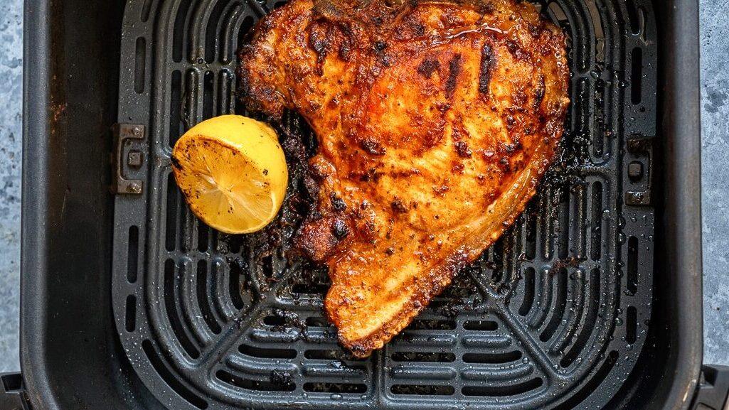 pork chop in the basket of an air fryer