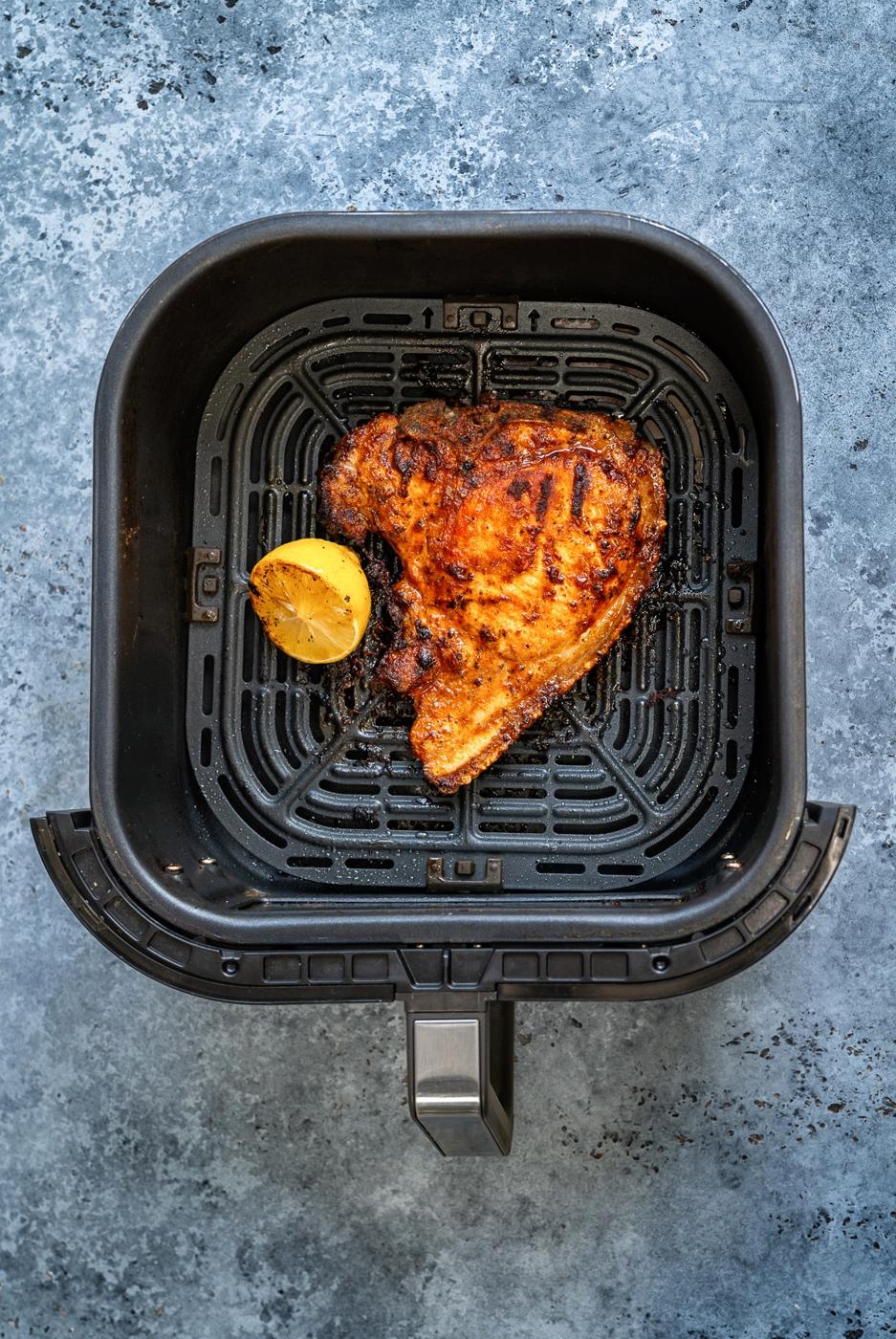 pork chop in the basket of an air fryer