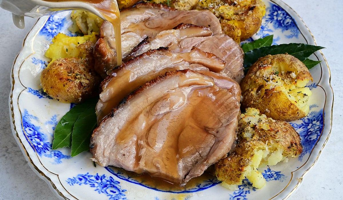 sliced roast pork served with potatoes and gravy