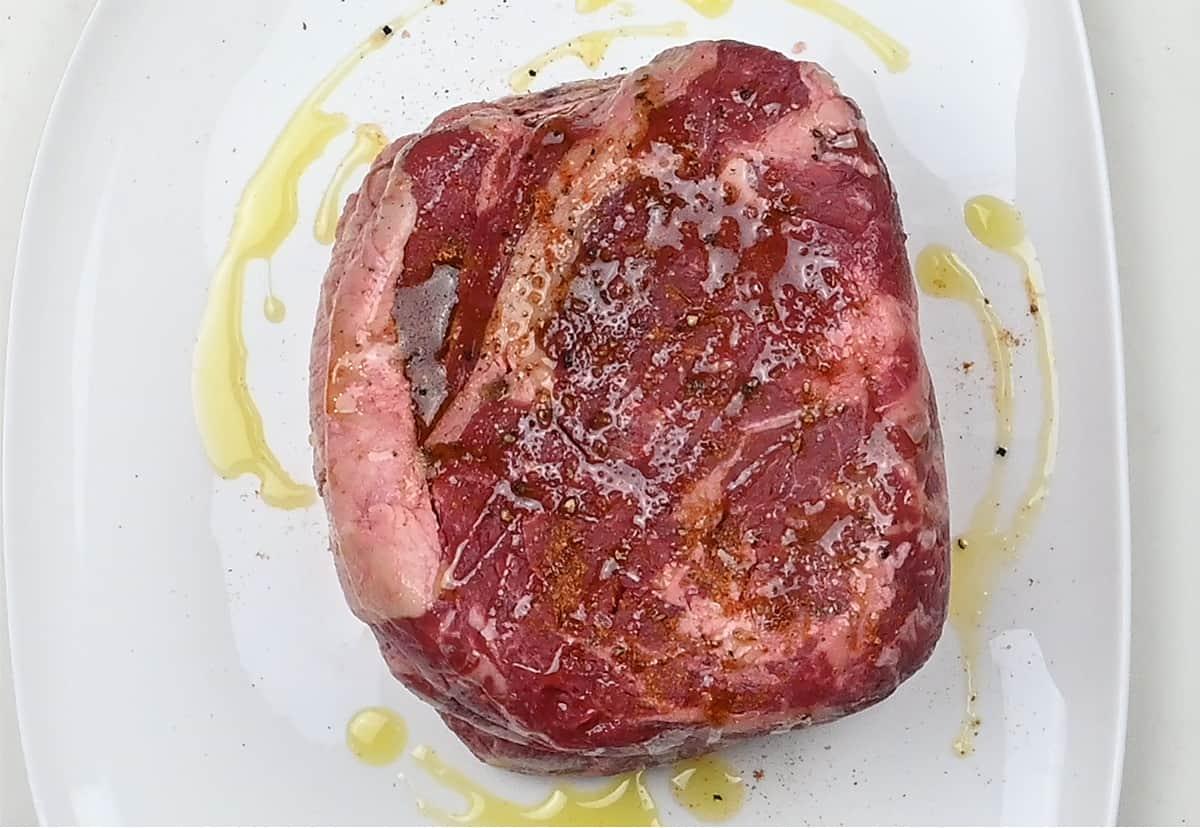 Boneless prime rib joint seasoned on a plate