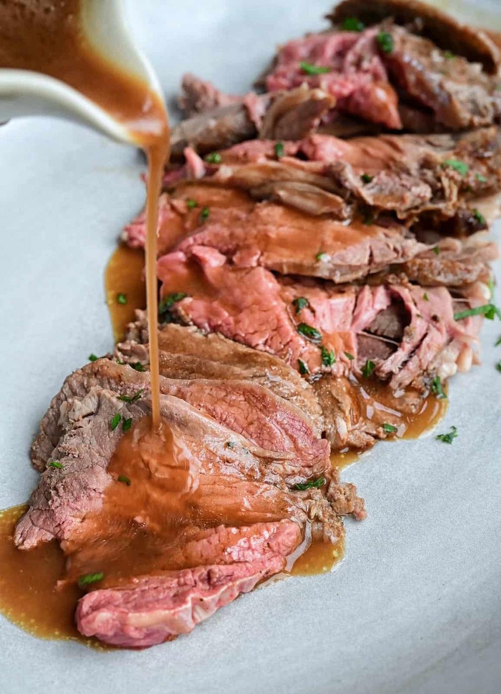Tender roast beef slices with gravy on a platter