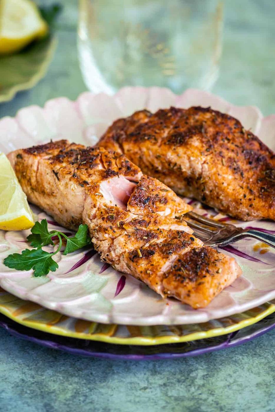 Salmon fillets on plate, one flaked
