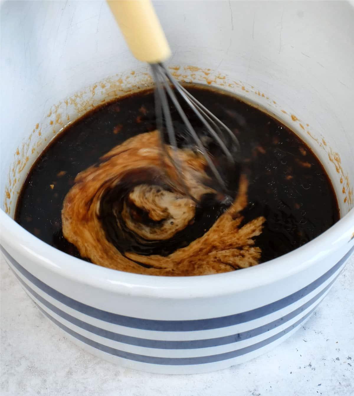 mixing cornstarch slurry into marinade in saucepan