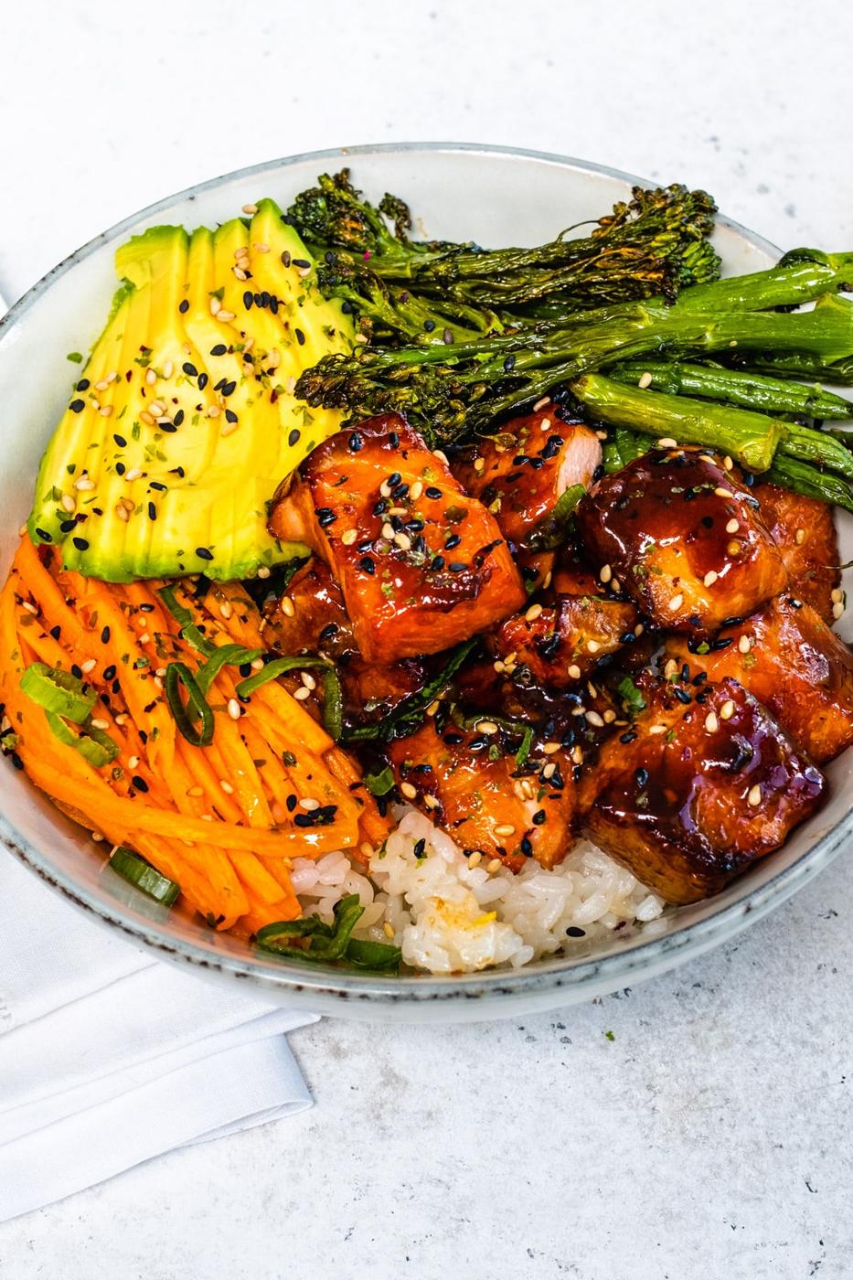 Salmon rice bowl with vegetables, avocado and sushi rice
