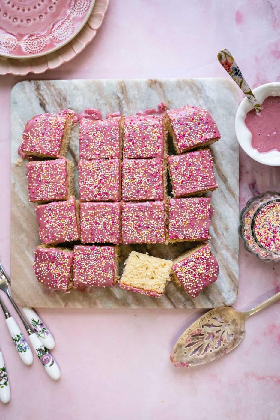 Sliced School cake with pink glaze and sprinkles. overhead view
