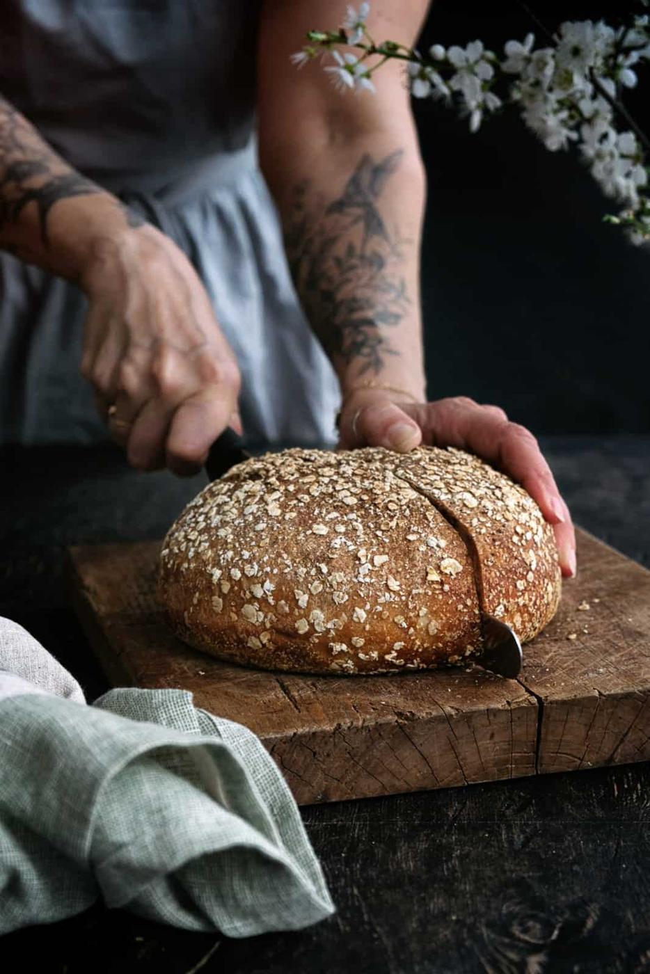 Slicing through a loaf of Air Fryer Sourdough bread