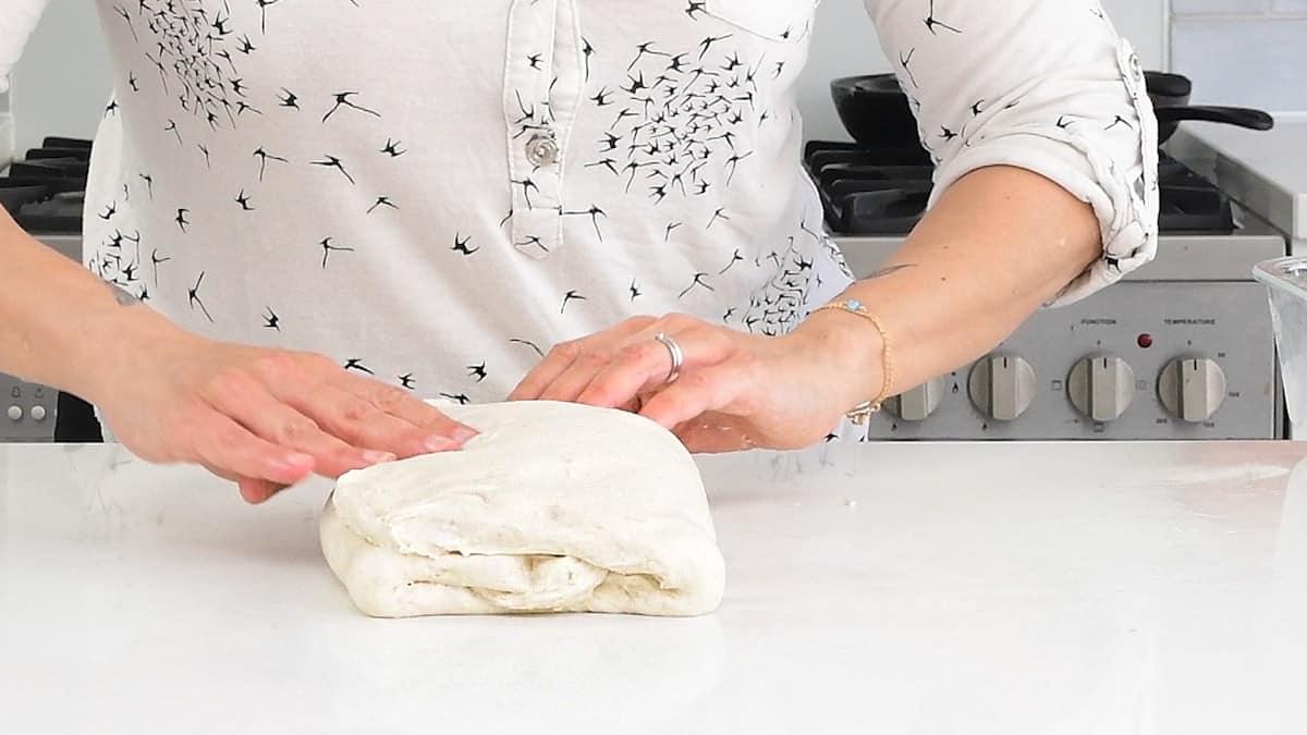 Folding thebread dough into three sections, like a letter (letter fold).