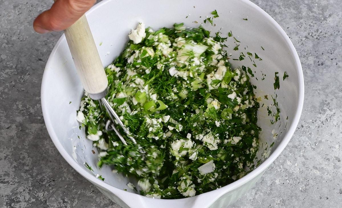 making spinach and feta filling in a bowl