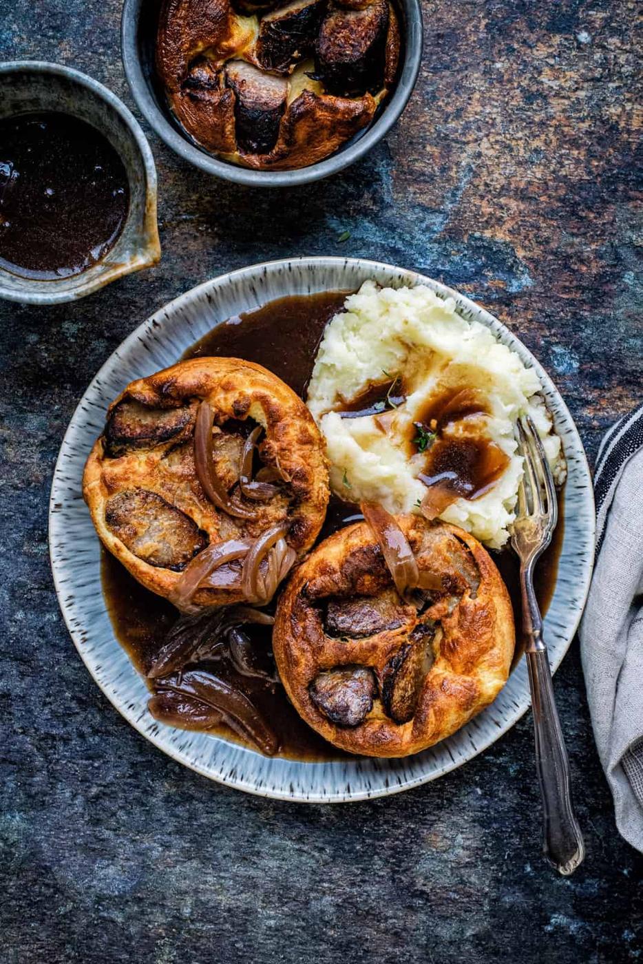 British Toad in the hole with mashed potatoes and gravy on a plate