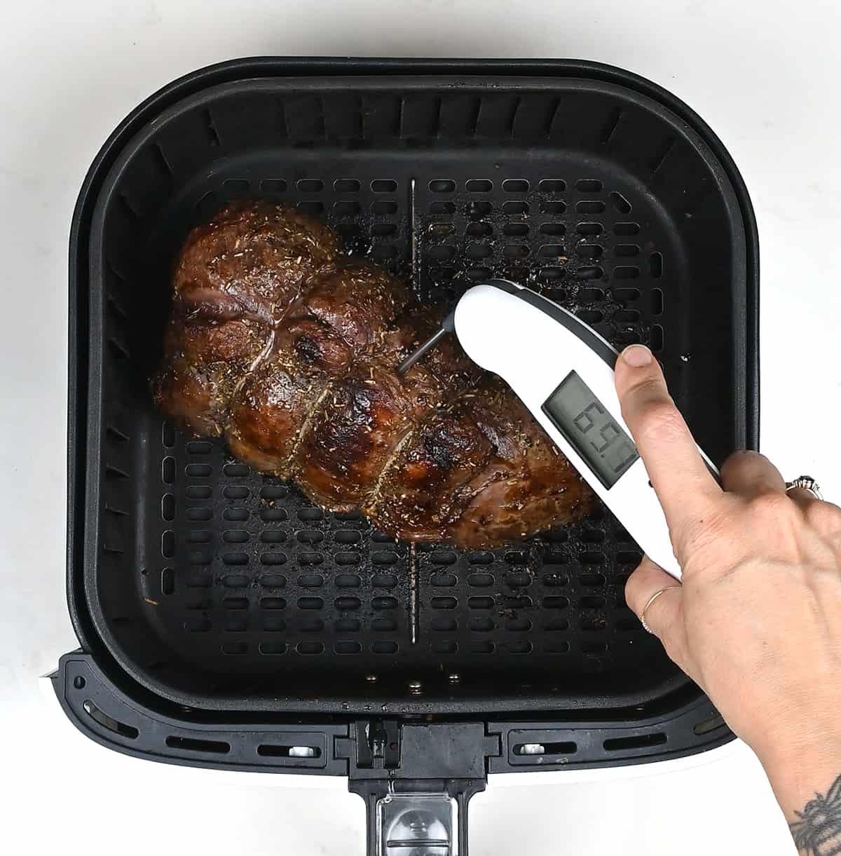 checking the temperature of air fryerroast venison with a meat thermometer