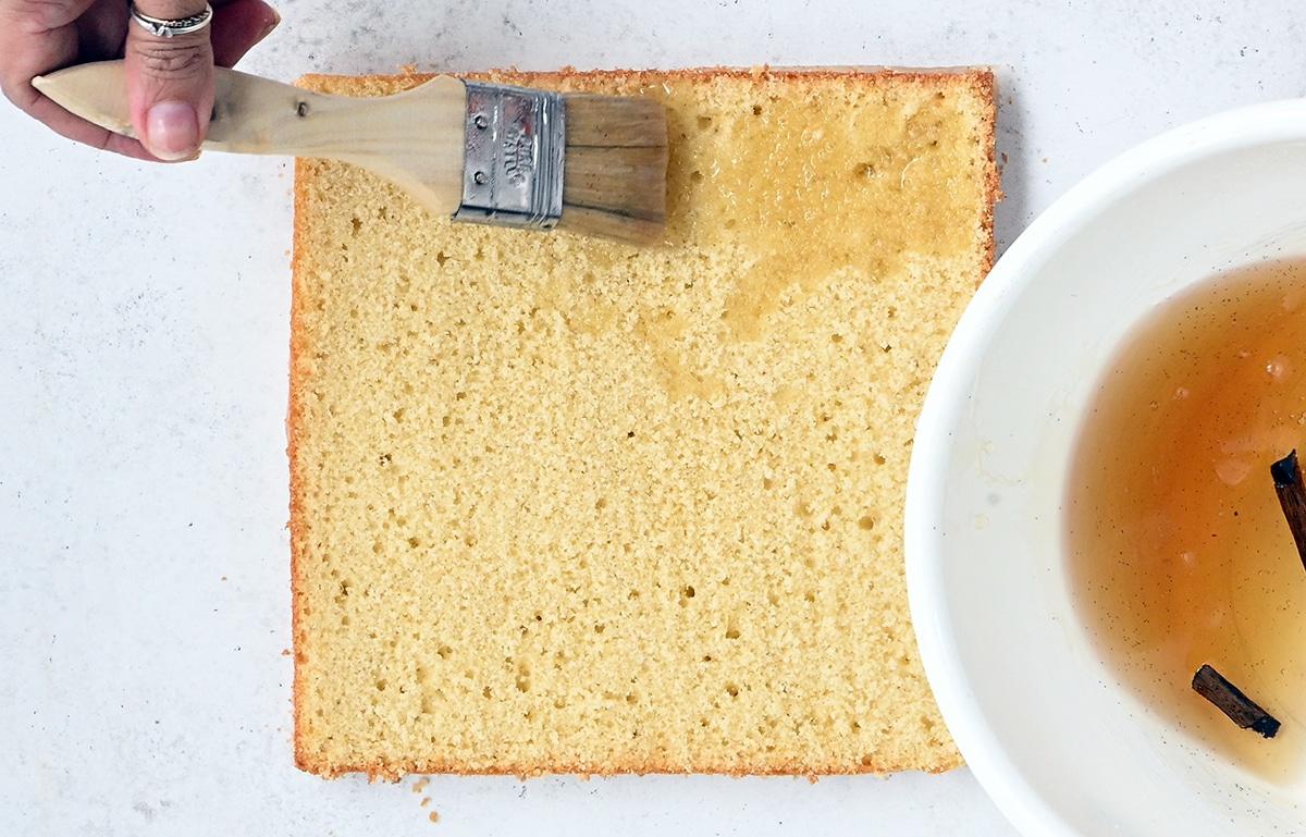 brushing sponge cake with vanilla syrup