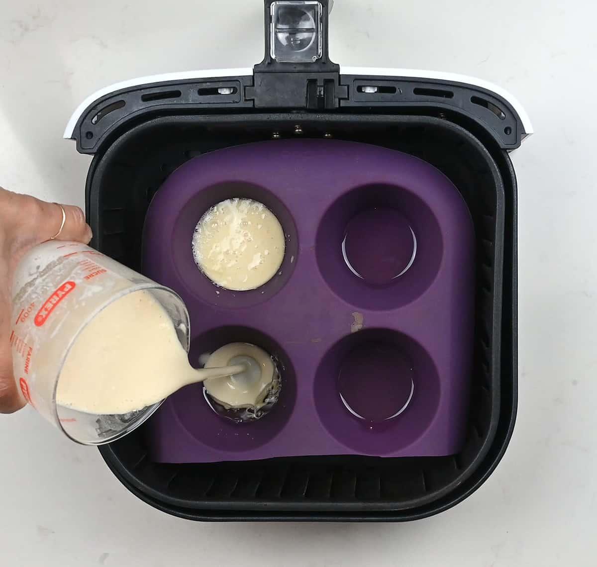 Pouring batter into silicone muffin til for Yorshire puddings
