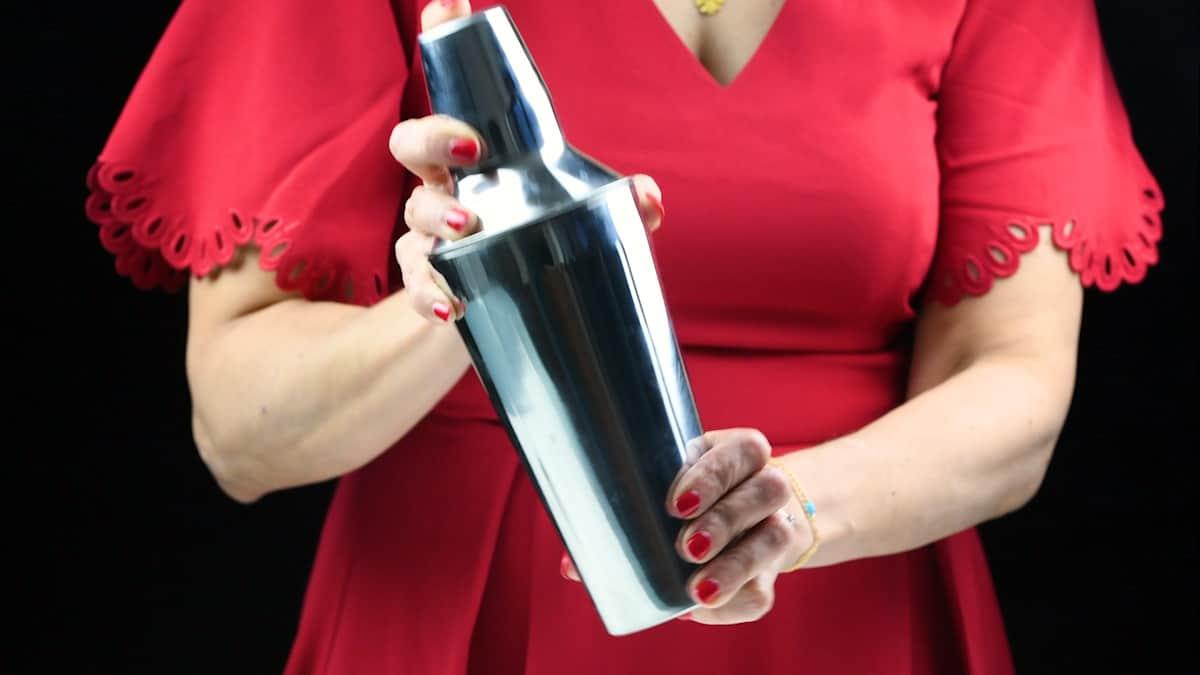 woman wearing red dress shaking a cocktail shaker