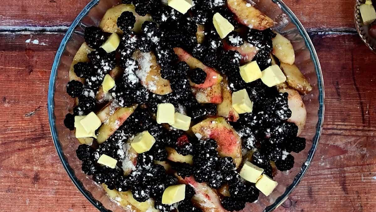 pie dish with apples and blackberries tossed with sugar, flour, cinnamon and cubed butter