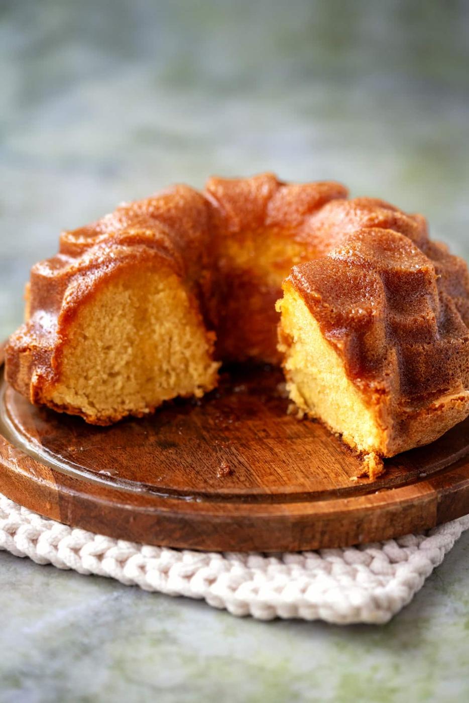 sliced Bacardi rum cake on a wooden cake plate