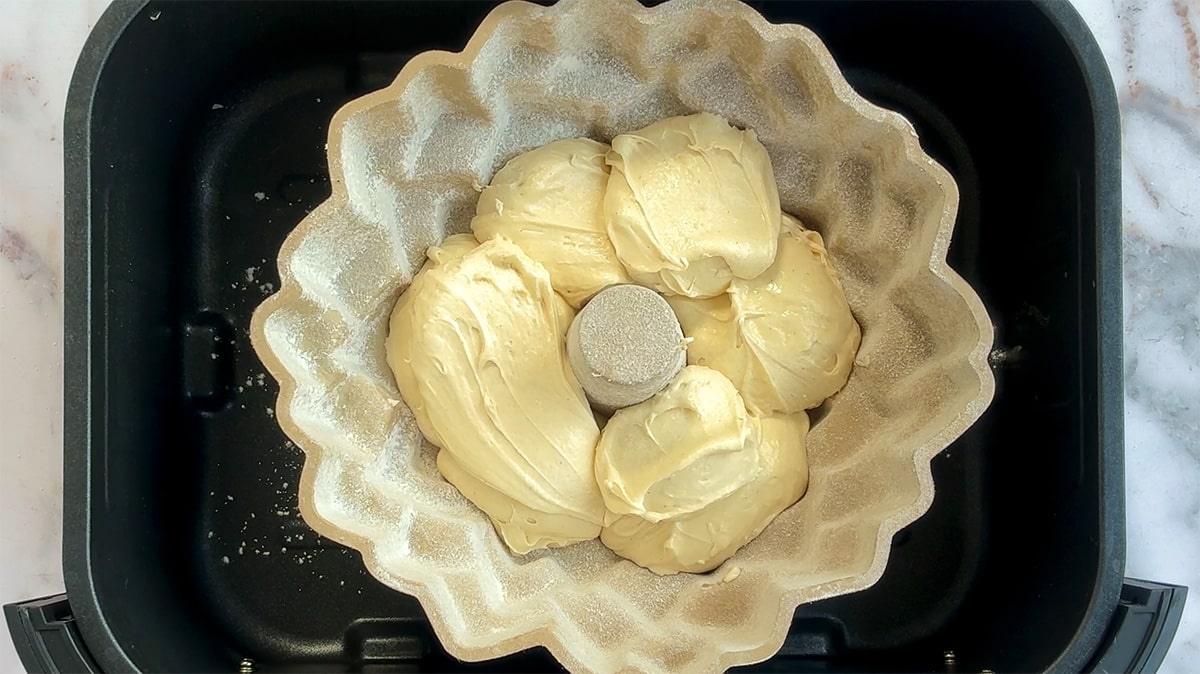 adding cake batter to a bundt pan