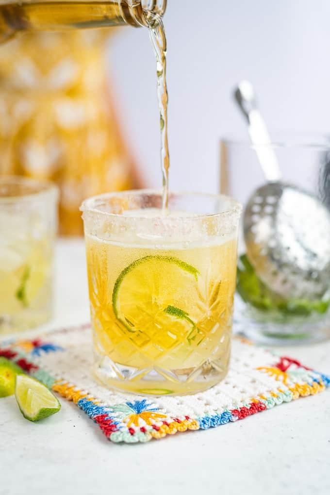 Pouring Corona beer into a glass of margarita cocktail