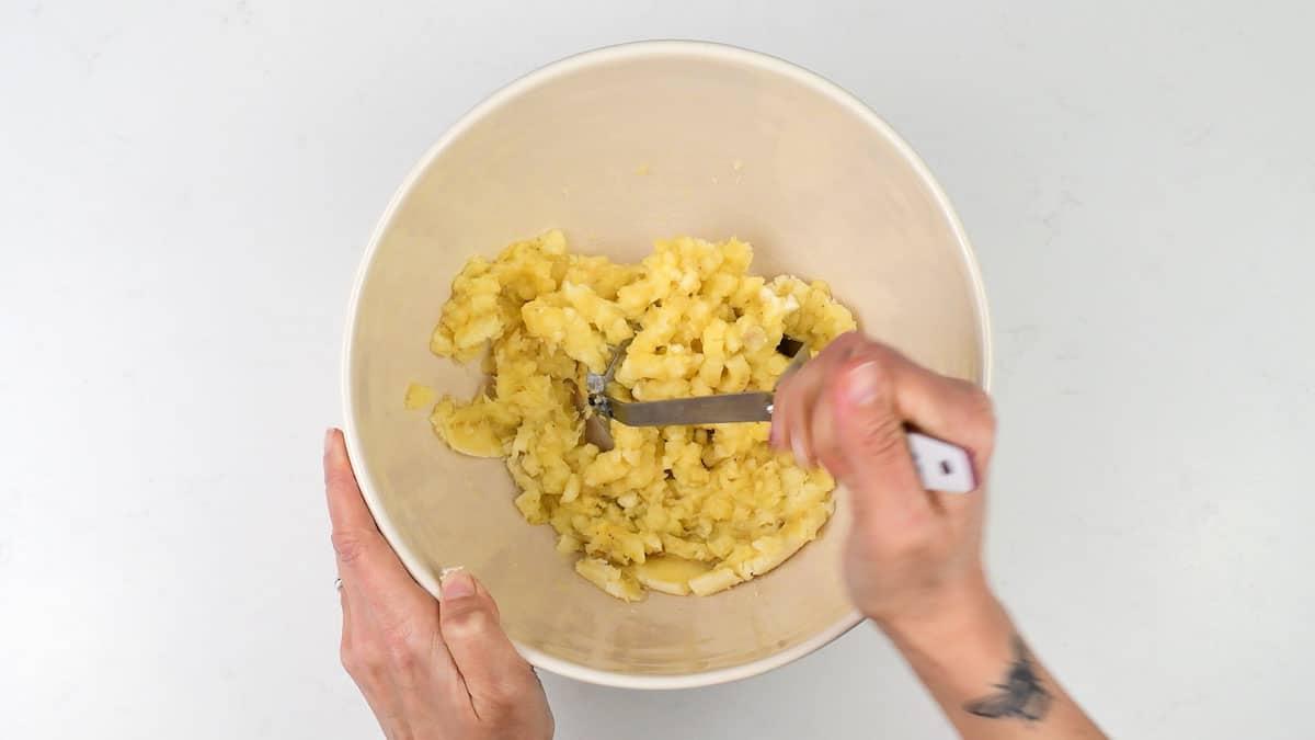 Mashing bananas in a mixing bowl